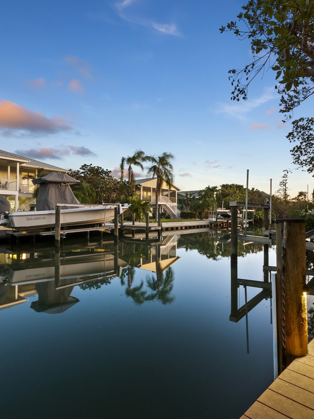 Peaceful view of a Longboat Key canal lined with private docks and boats at sunset, showcasing the island’s waterfront lifestyle.