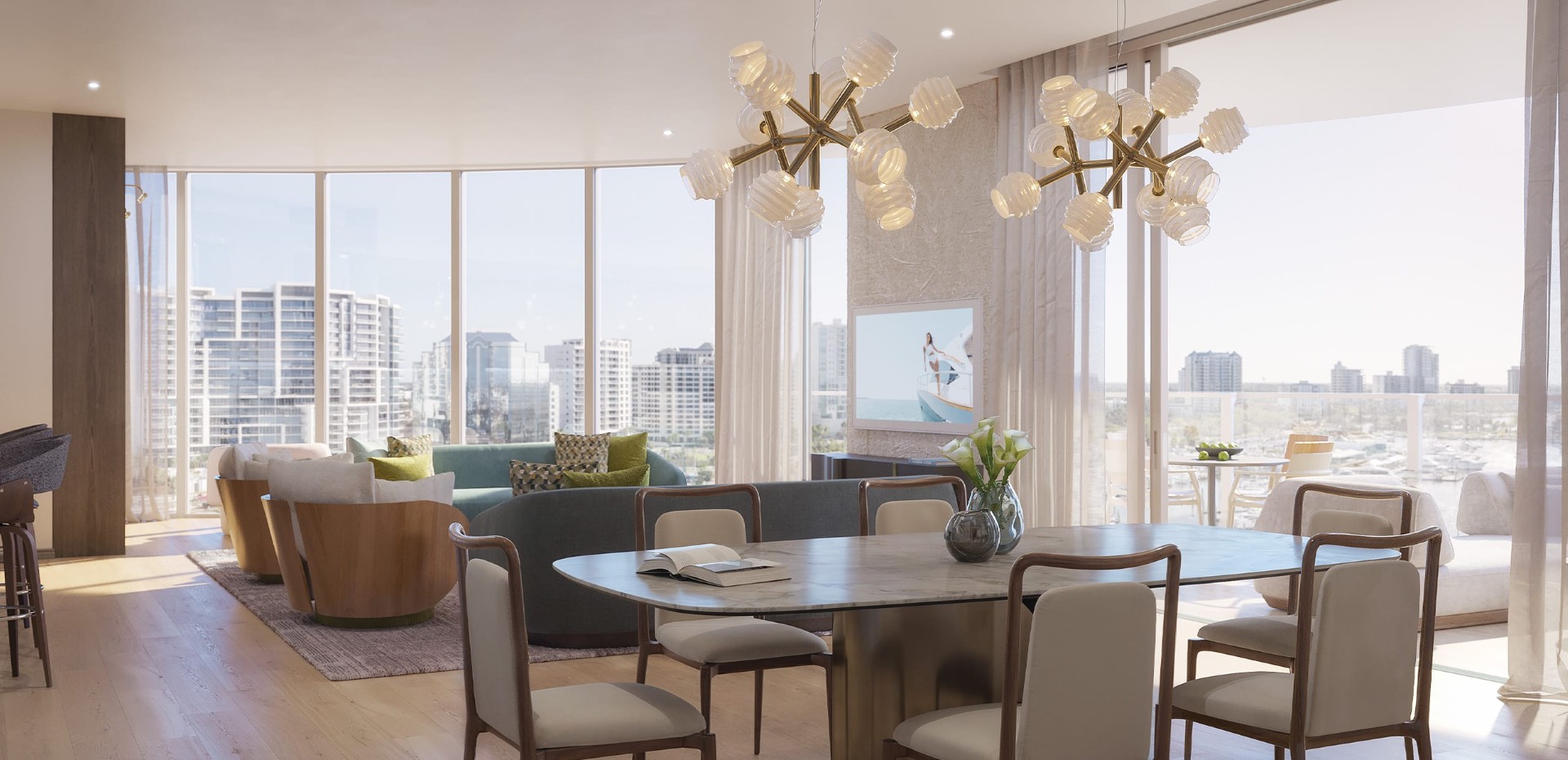 Open-concept living area at Amara on Sarasota Bay featuring floor-to-ceiling glass, modern furnishings, natural wood floors, and expansive views of Sarasota Bay.