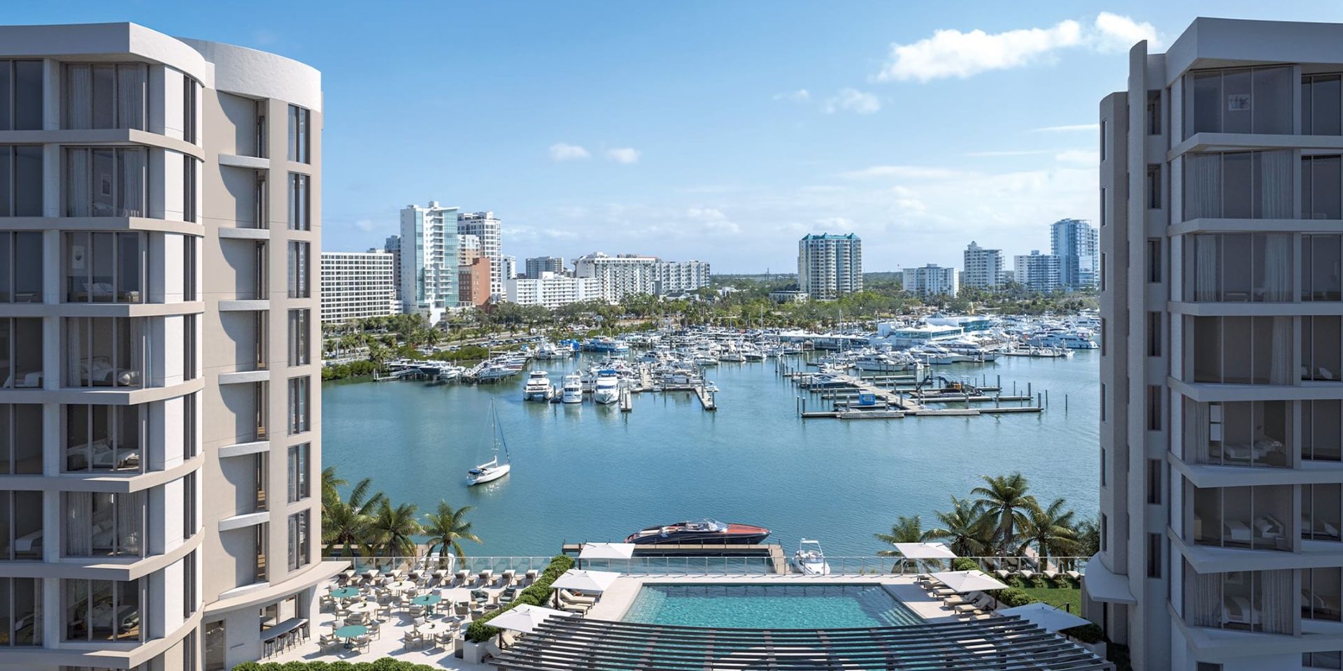 Elevated view of a full-service marina on Sarasota Bay featuring boat slips, waterfront pool amenities, and downtown Sarasota in the background, reflecting the bayfront lifestyle near Amara.