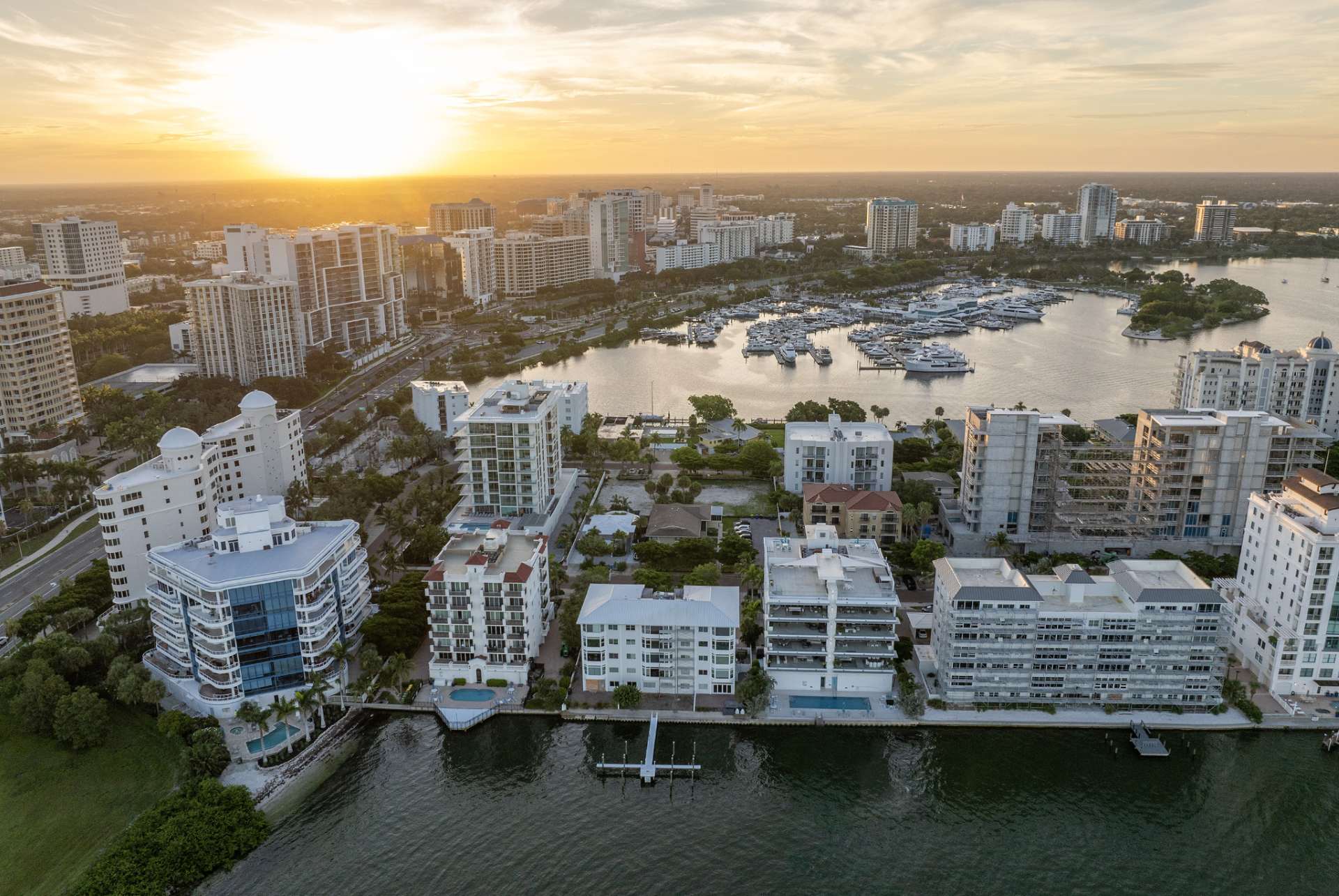 Drone view of Golden Gate Point waterfront skyline with marina, luxury condominiums, and Sarasota Bay at sunset