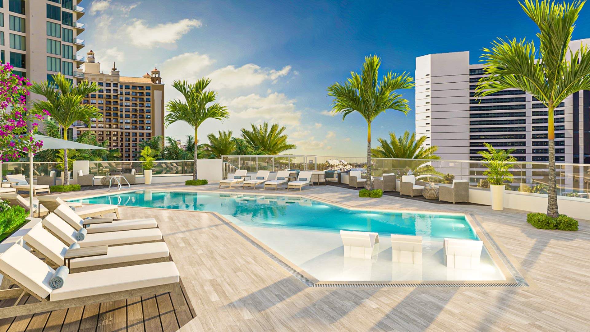Resort-style elevated pool terrace at The Ritz-Carlton Residences Sarasota Bay featuring sun shelf loungers, palm trees, and panoramic views of downtown Sarasota and the waterfront.