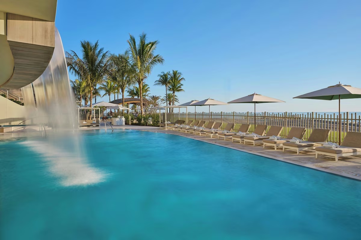 Swimming pool at St. Regis Longboat Key with lounge chairs, umbrellas, and panoramic views of the Gulf.
