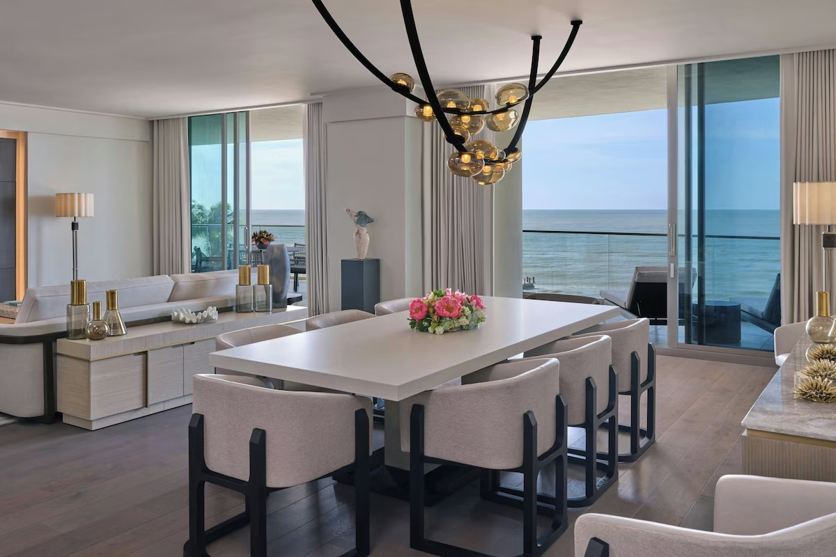 Open-concept living and dining area at St. Regis Longboat Key Residences with designer furnishings and expansive Gulf-front windows.