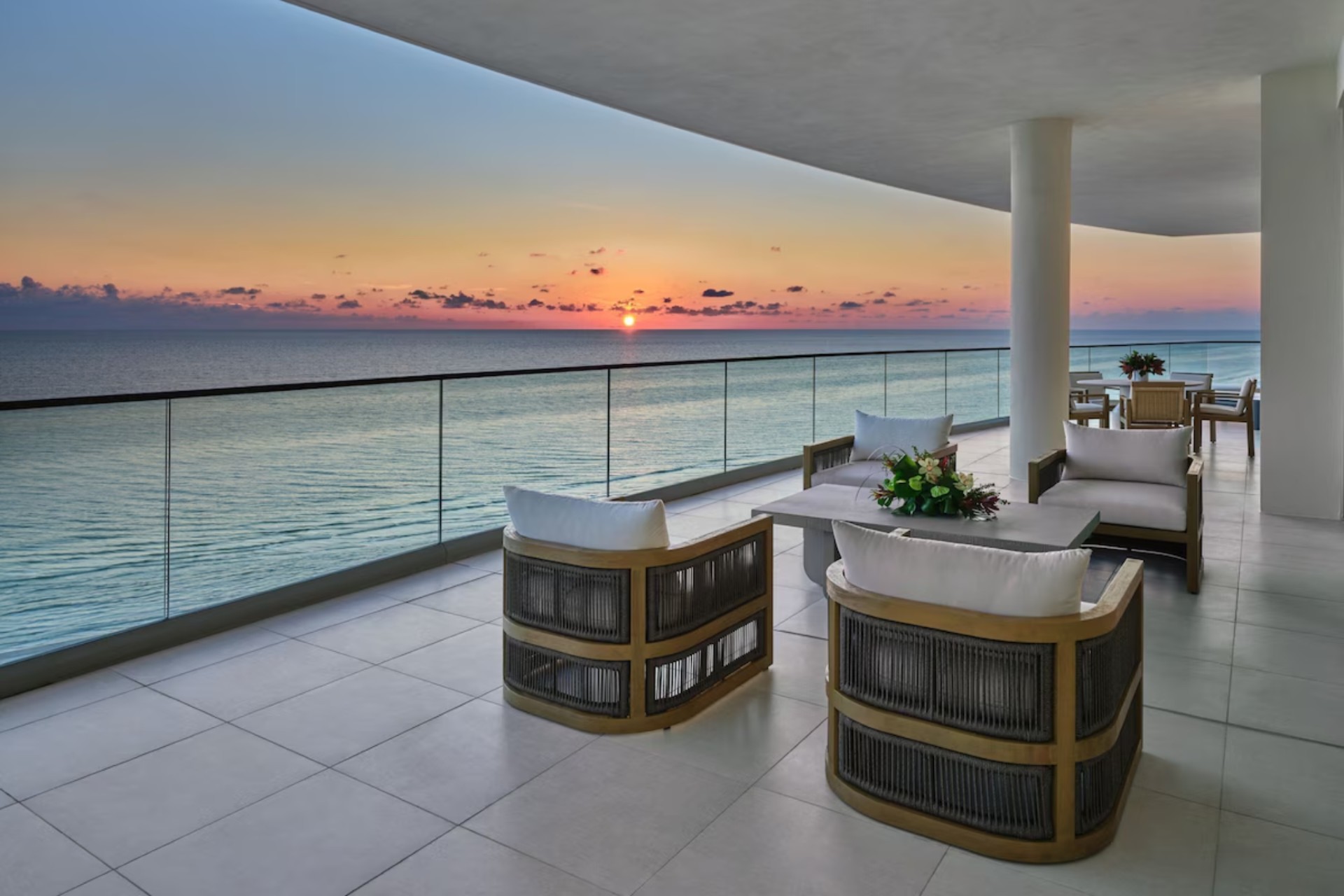 Resident-only outdoor lounge terrace at St. Regis Longboat Key with seating areas overlooking the Gulf of Mexico at sunset.