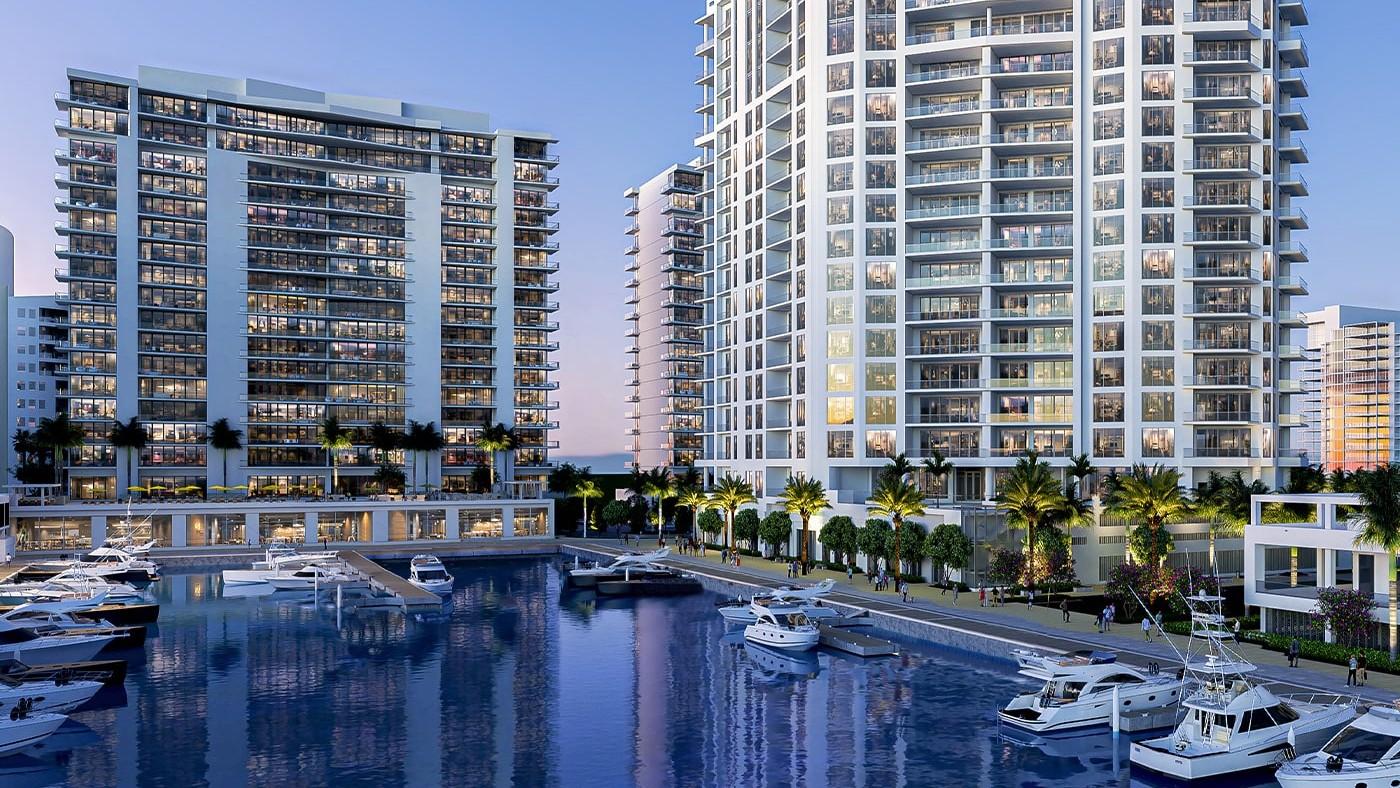 Private waterfront marina at The Ritz-Carlton Residences Sarasota Bay featuring luxury yacht slips, waterfront promenade, and residential towers overlooking Sarasota Bay.