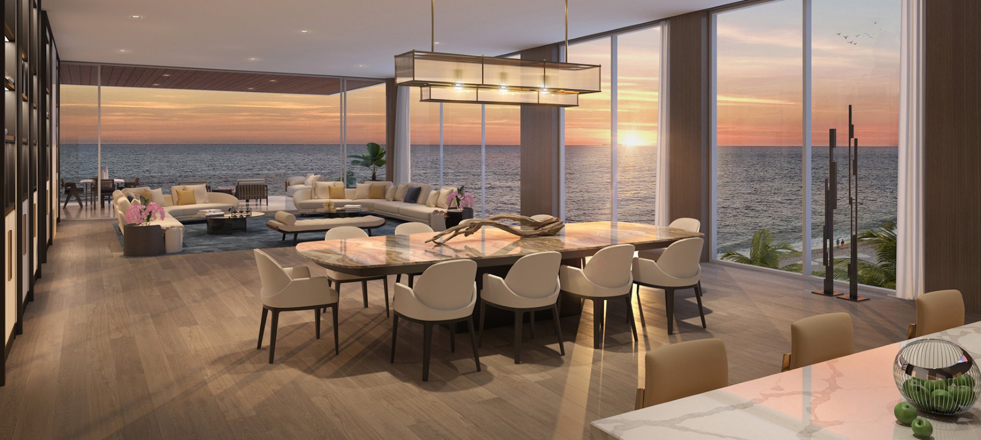 Open-concept living and dining area at Sage Residences on Longboat Key featuring floor-to-ceiling windows, modern furnishings, expansive Gulf of Mexico sunset views, and seamless indoor-outdoor design.
