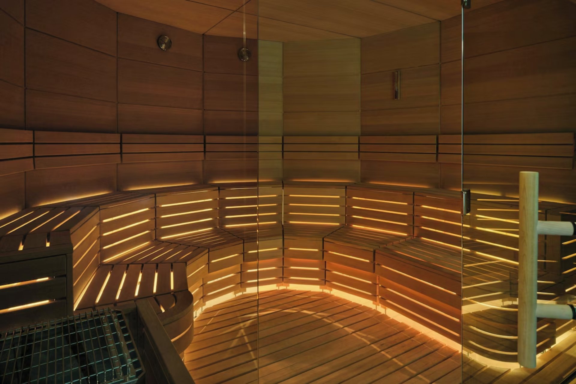 Interior of the sauna at the St. Regis Longboat Key spa with wood finishes, ambient lighting, and a tranquil wellness setting.