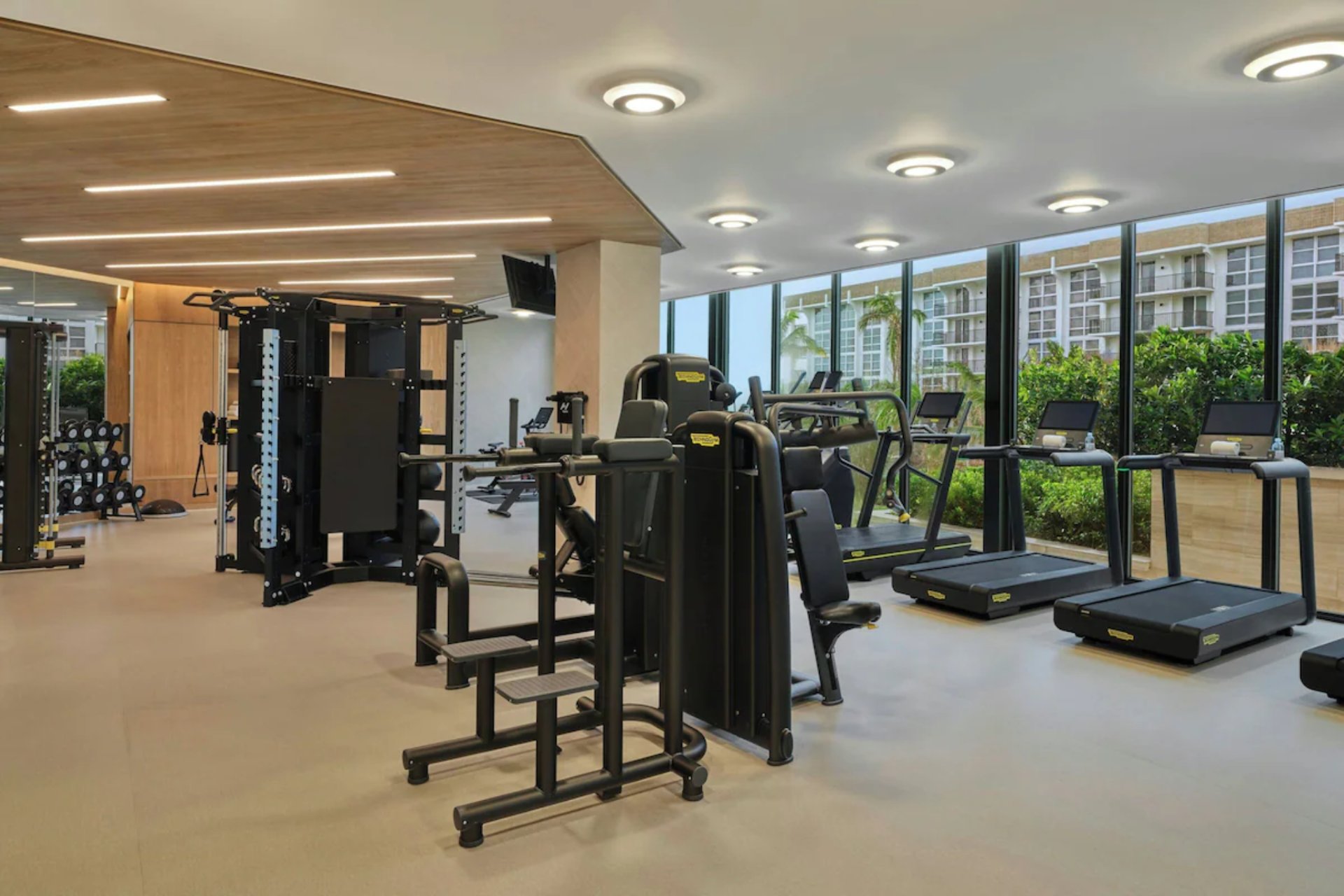Modern fitness center at St. Regis Longboat Key featuring advanced workout equipment and floor-to-ceiling windows.