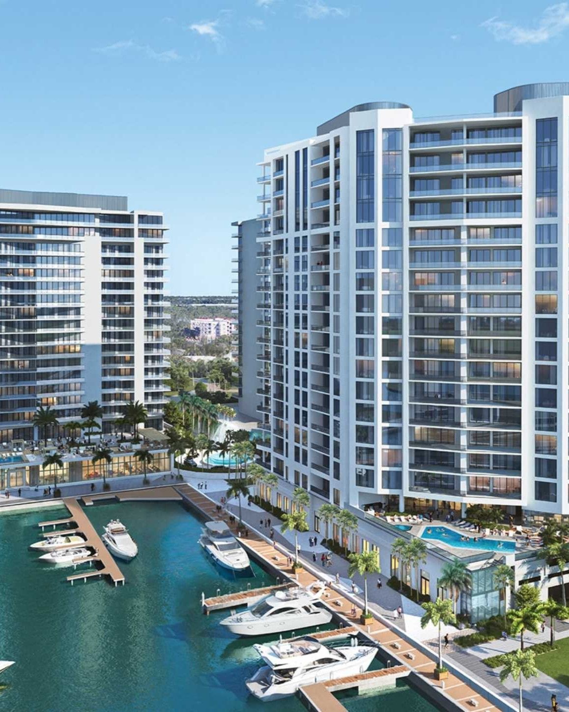 The Ritz-Carlton Residences Sarasota Bay featuring twin waterfront towers, private marina with yacht slips, resort-style pool deck, and landscaped promenade along the bay.
