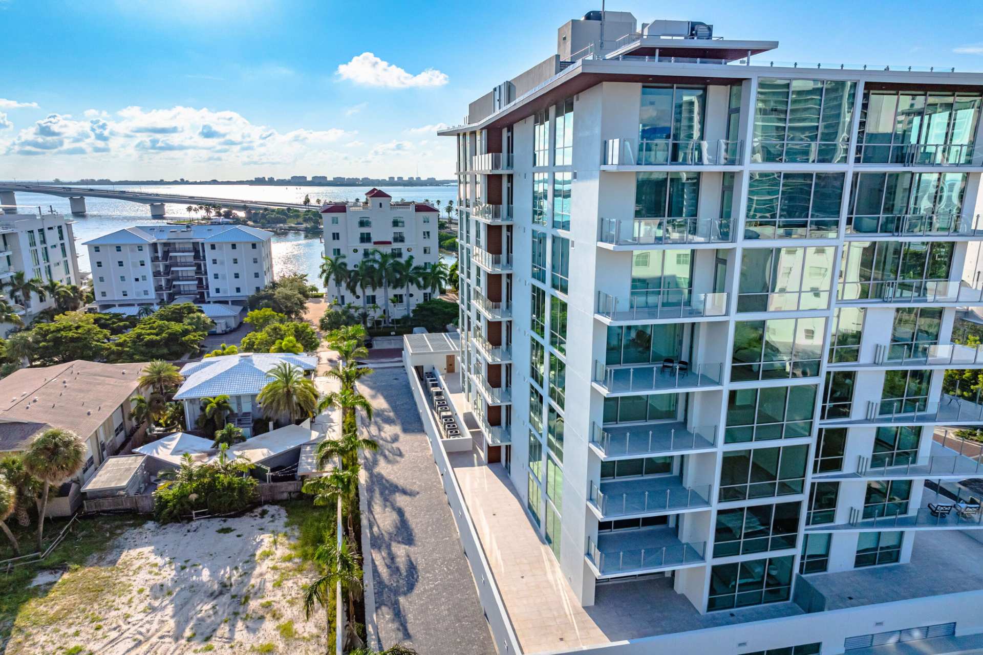 Aerial perspective of The Evolution luxury condominium with glass balconies and Sarasota Bay views near Golden Gate Point