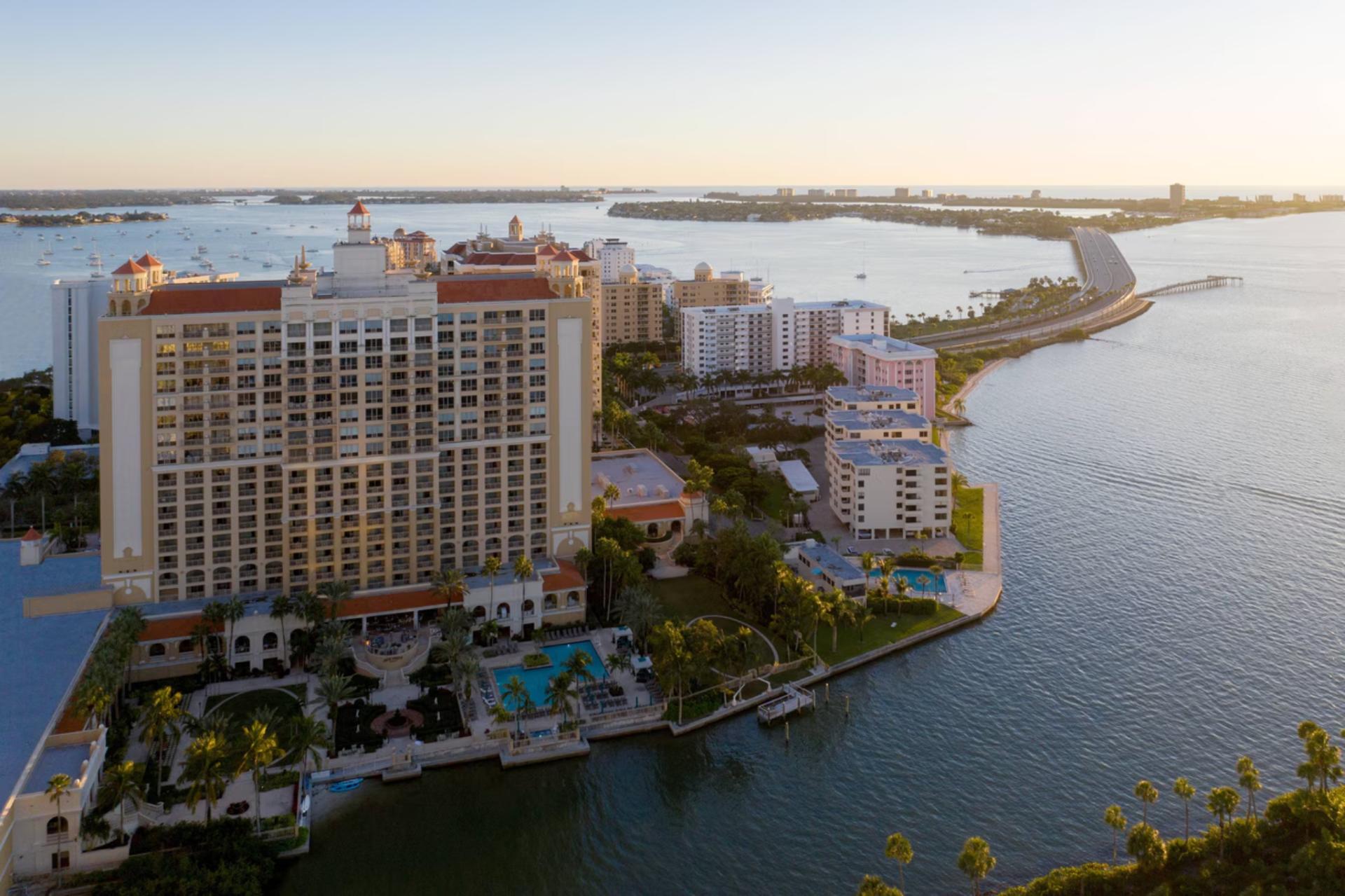 Aerial view of The Ritz-Carlton Sarasota overlooking Sarasota Bay with waterfront pool, marina, and city skyline