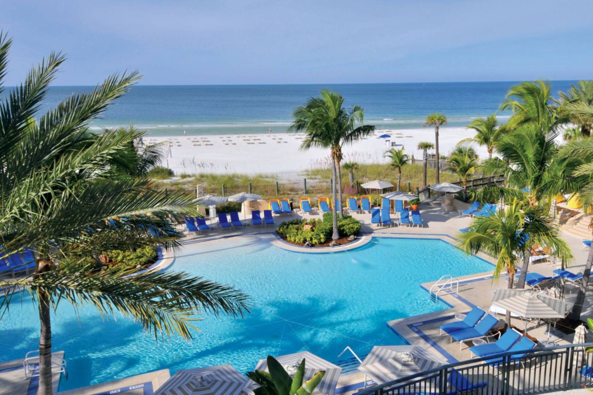 Beachfront pool with lounge chairs and ocean views at The Ritz-Carlton Beach Club near Sarasota
