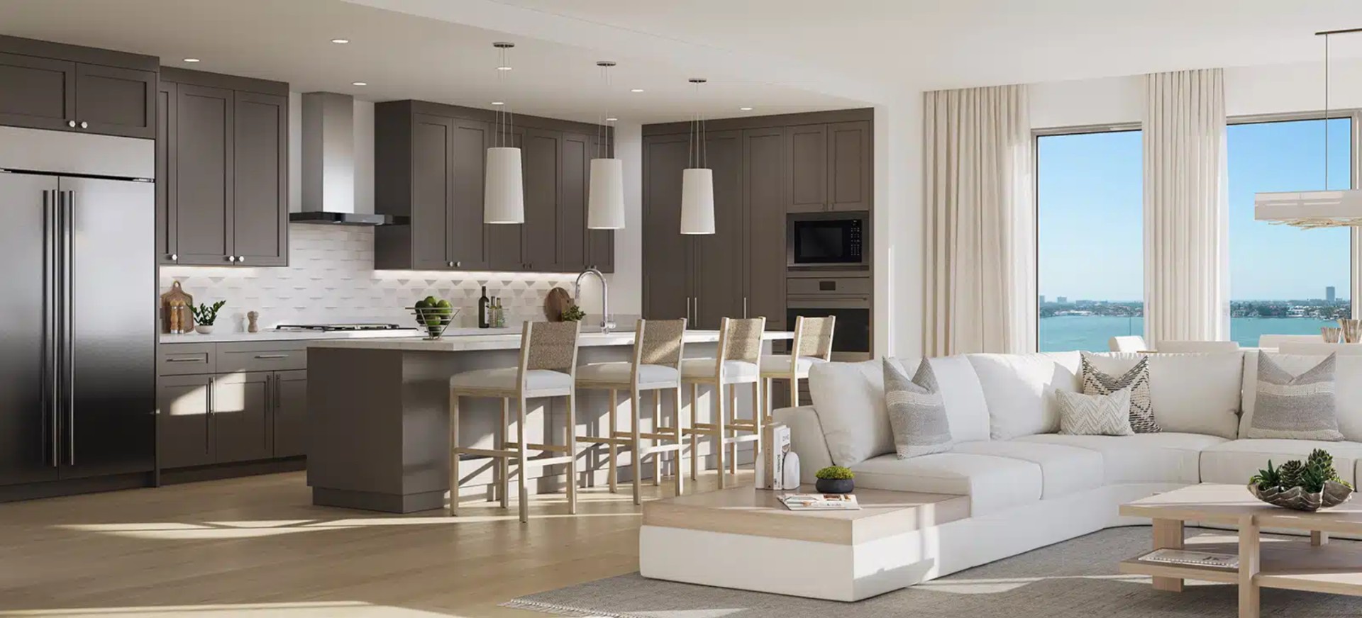 Luxury kitchen at The Owen Sarasota with custom cabinetry, large island seating, modern appliances, and open layout connected to living space.