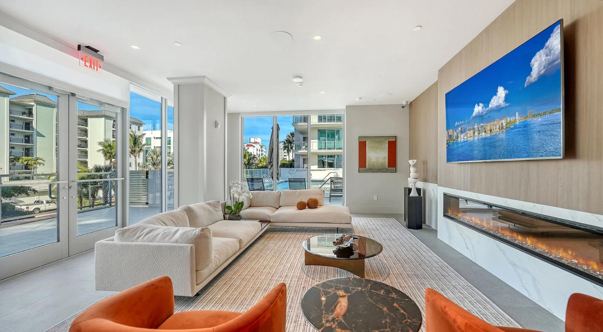 Modern resident lounge with fireplace, seating area, and pool views at Peninsula Sarasota luxury waterfront residences