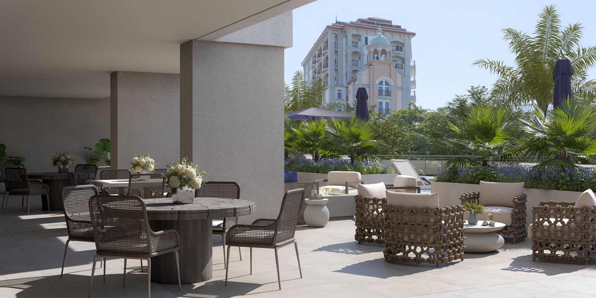 Landscaped outdoor terrace at The Owen Sarasota featuring lounge seating, dining areas, and lush greenery in a private courtyard setting.