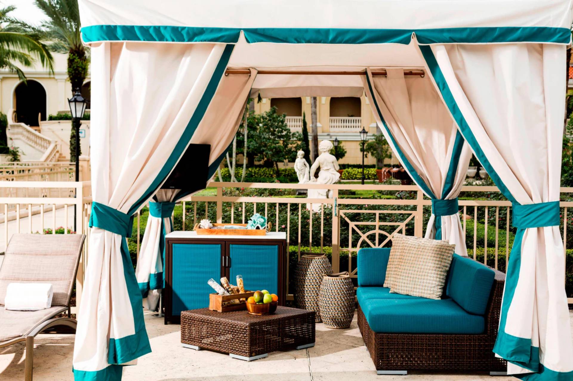 Luxury private cabana with seating and shaded drapery at The Ritz-Carlton Sarasota pool area