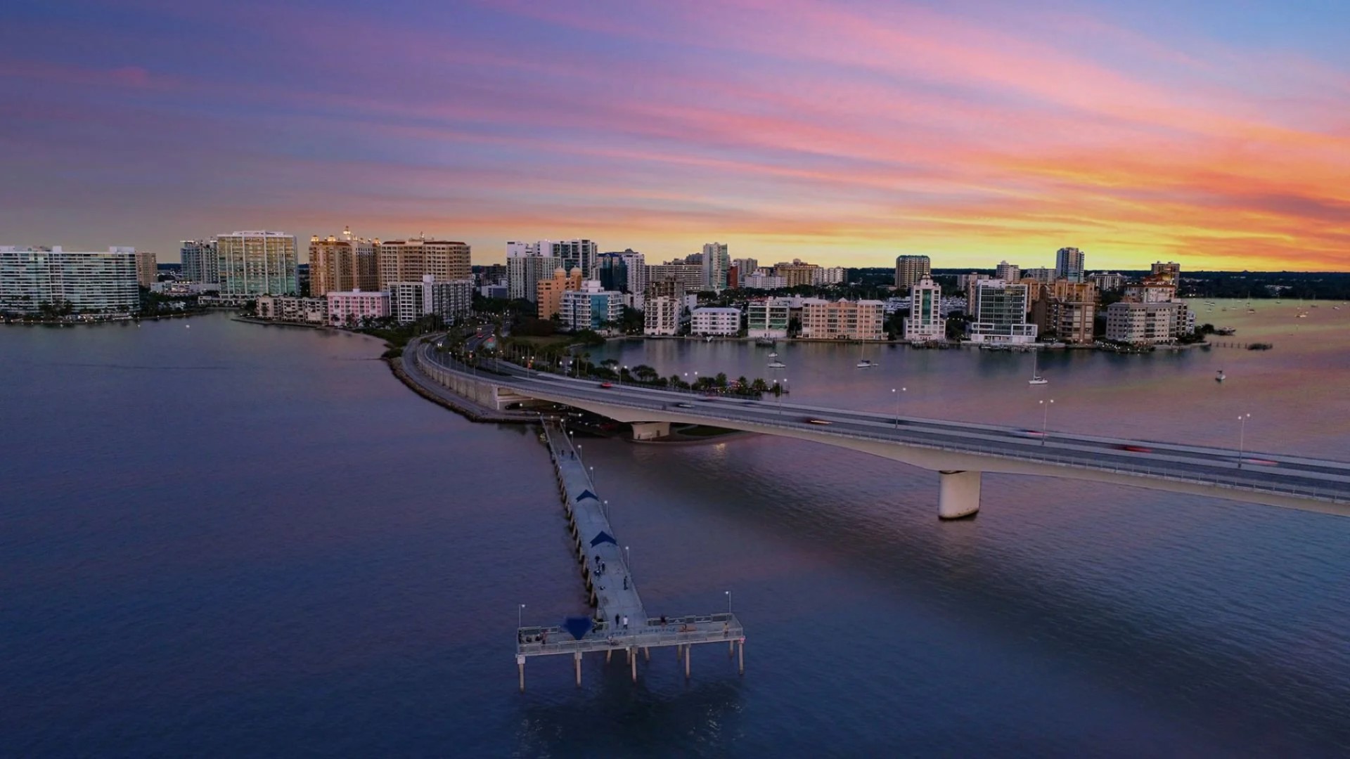 Sunset view of Sarasota Bay bridge and downtown skyline near Peninsula Sarasota waterfront residences
