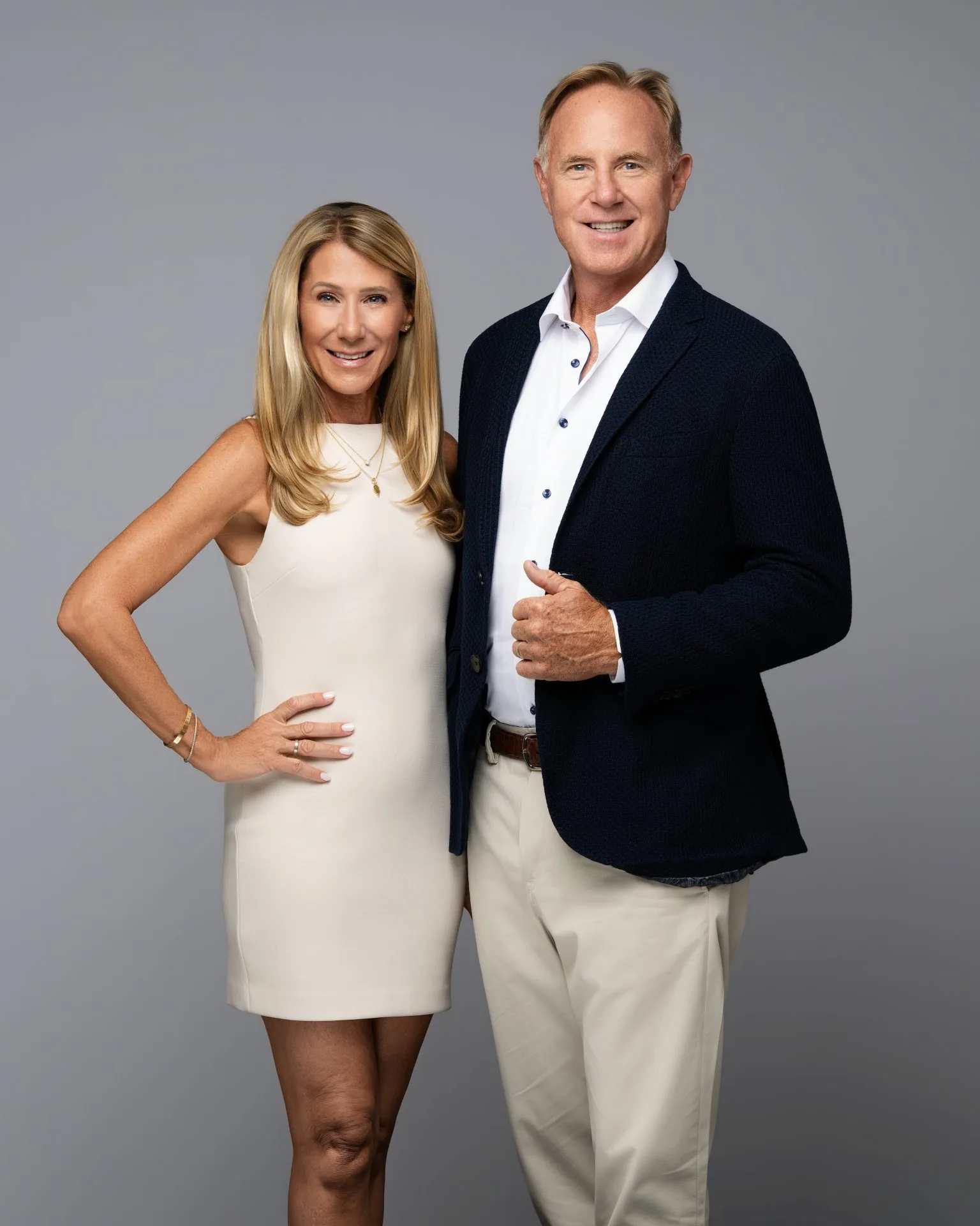 Janet and Steve Walter of Walter Group standing together in professional attire against a gray background.