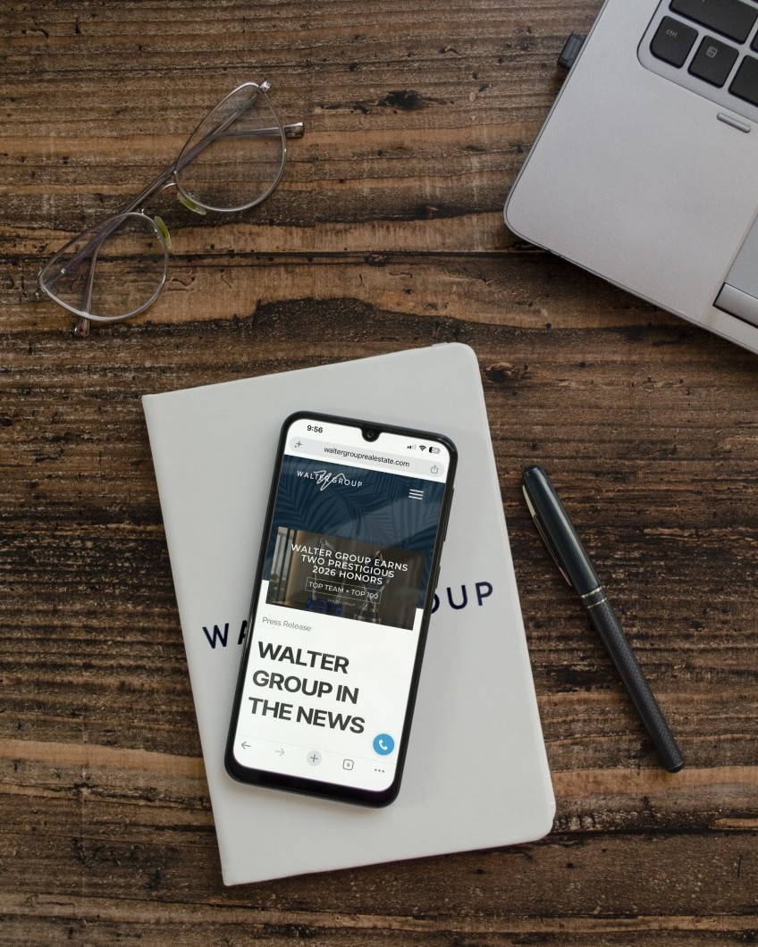 Walter Group press releases and real estate news displayed on a smartphone with Walter Group branded materials.